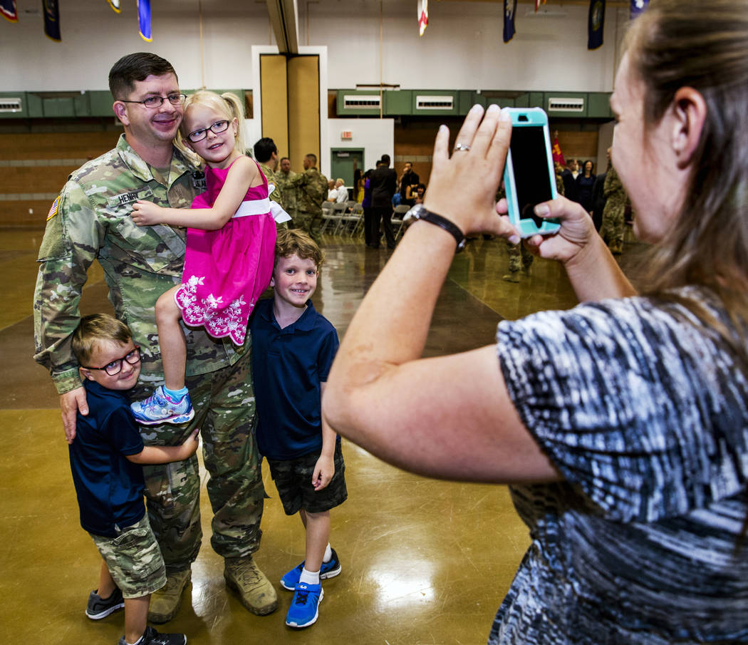 1st Lieutenant David Henry holds his daughter Karagan, 5, with son's Carrick, 5, left, and Owei ...