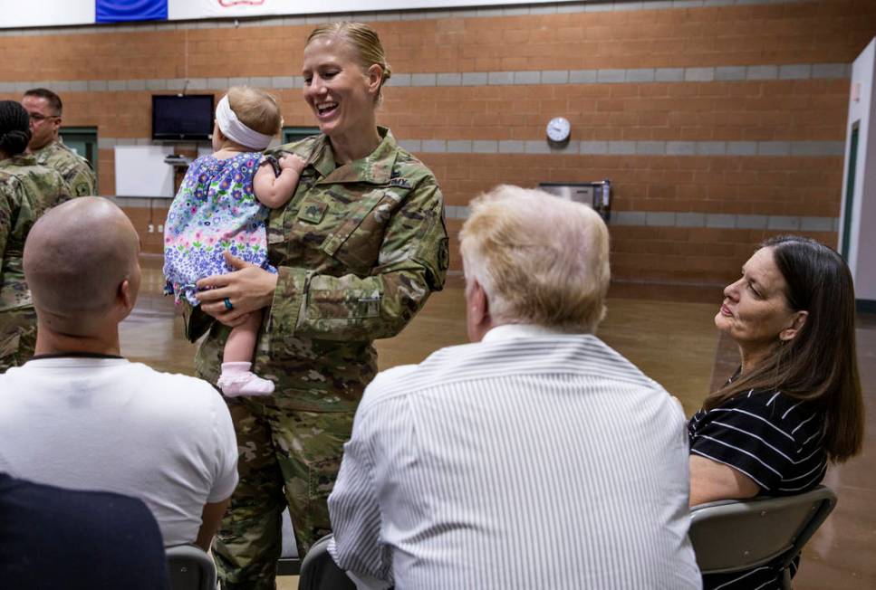 Sgt. Jessica Done holds her daughter Rylie, 8-month-old, as she talks with family before a mobi ...