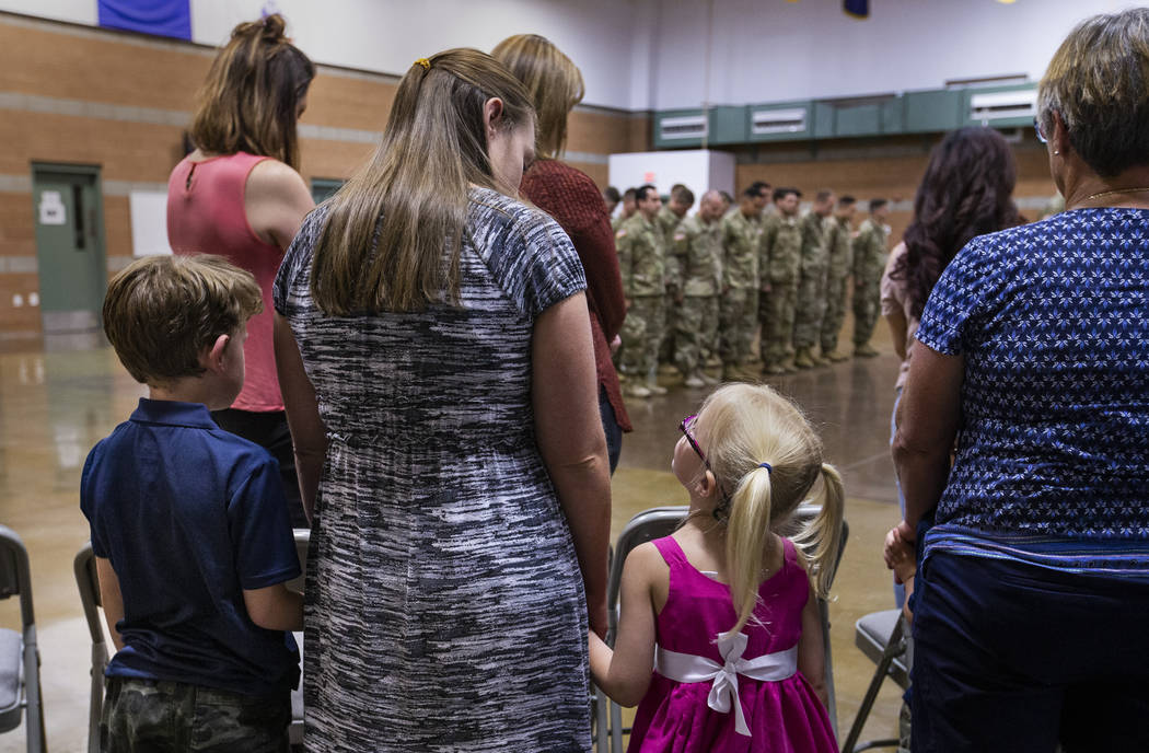 (From left) Owein Henry, 7, holds his mother Diana's hand as she looks down to daughter Karagan ...