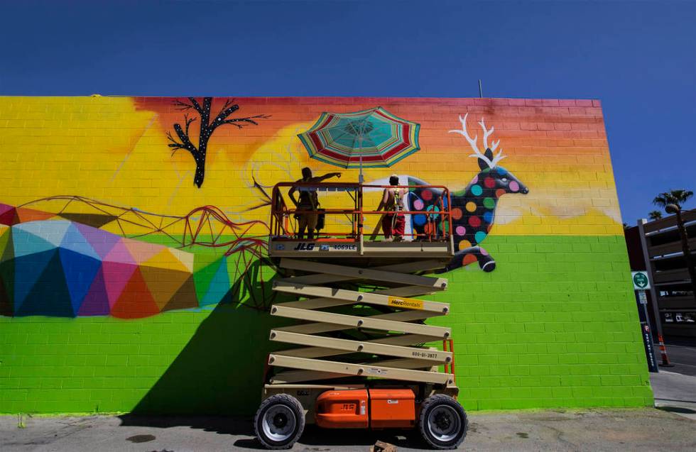 Artist Okuda San Miguel, left, works on a mural outside the Meow Wolf art motel on Monday, Sept ...