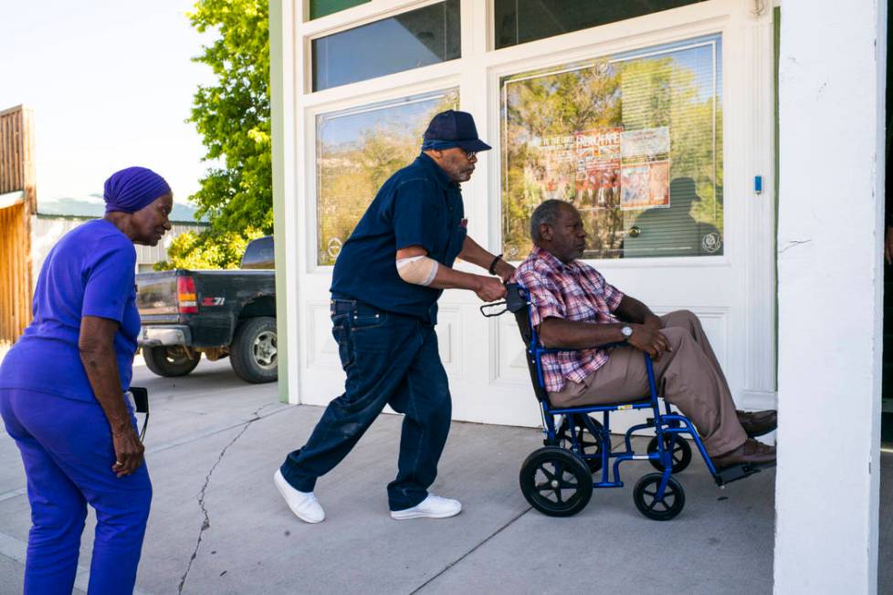 Paul Browning pushes the wheelchair of his brother, Tony, while his mother, Betty, looks on, as ...
