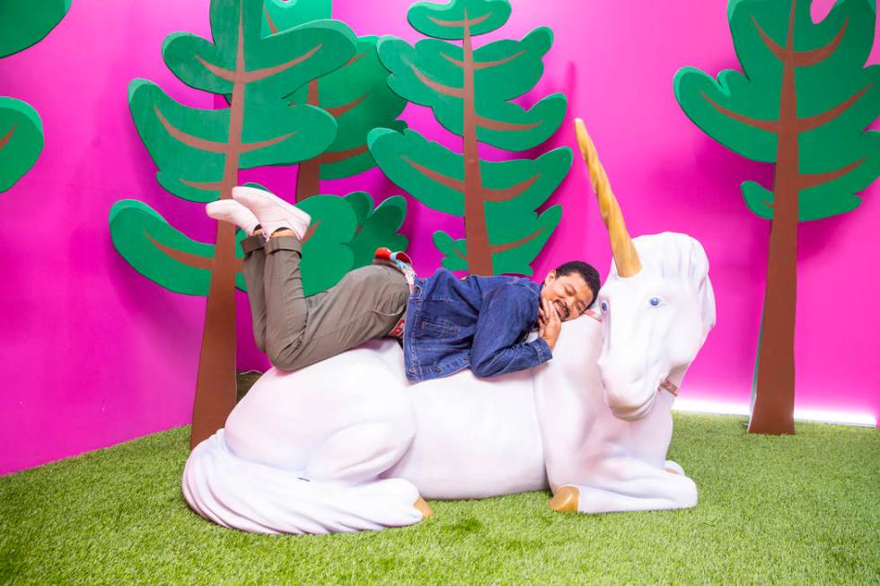 Chad Wilson snuggles up while in the Cornelius the Unicorn Room at the new Happy Place popup at ...