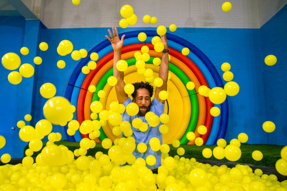 Bryce Hill pops up from the ball pit in the Pot of Happiness Room at the new Happy Place popup ...