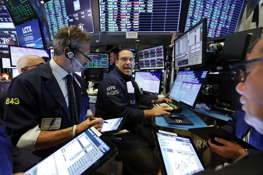 Specialist Anthony Matesic, center, works with traders at his post on the floor of the New York ...