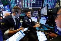 Specialist Anthony Matesic, center, works with traders at his post on the floor of the New York ...