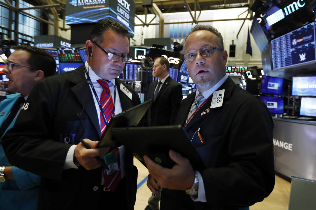 Traders Edward Curran, center, and Robert Arciero, right, work on the floor of the New York Sto ...