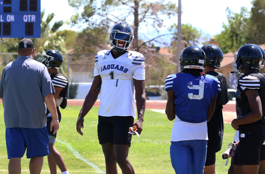 Desert Pines High School defensive lineman Darnell Washington (1) chats with his teammates befo ...