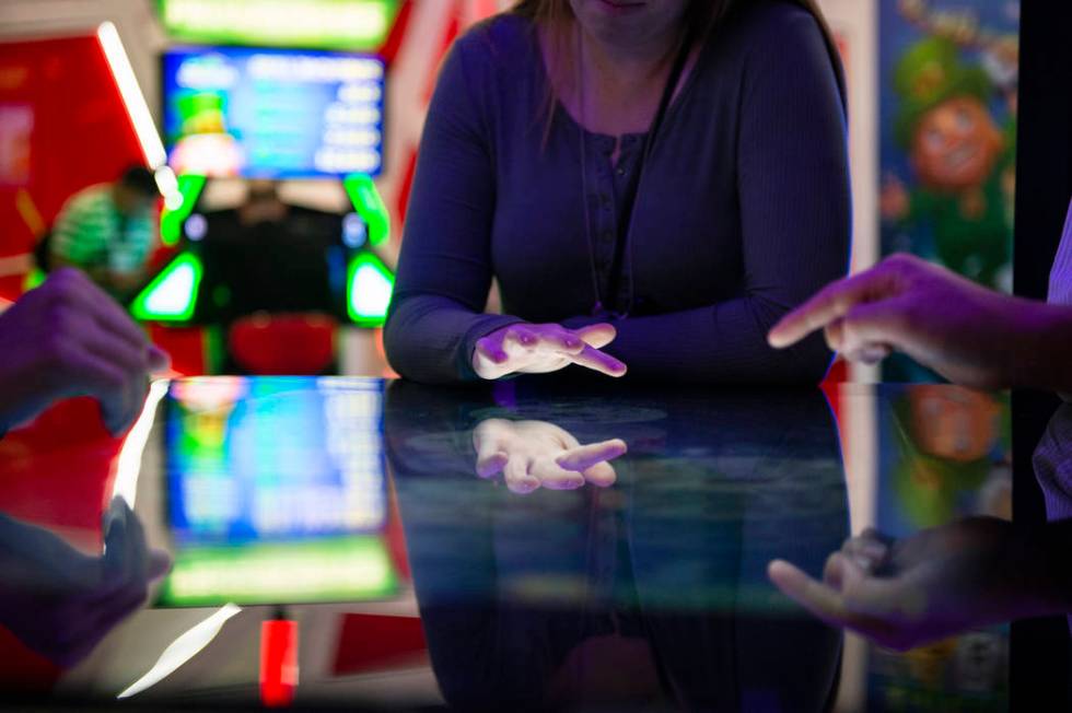 Attendees play a Deal or No Deal themed table game that uses touch screen technology at the Gam ...