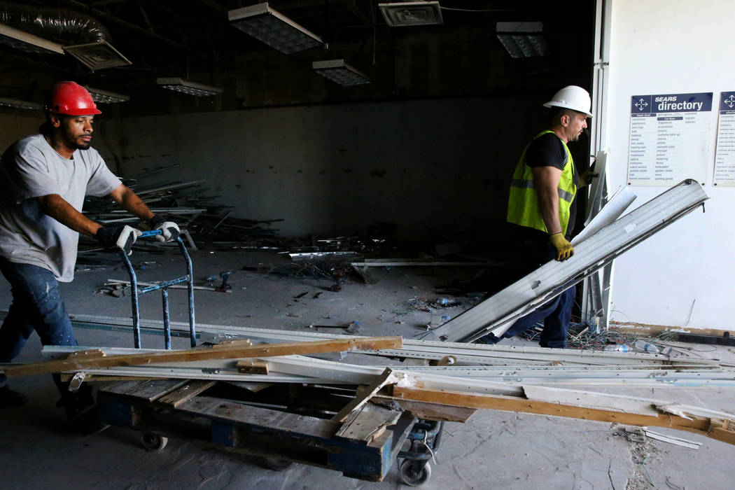 Workers Ivan Cruz, left, and Mike Istrate recycle building material inside the former Sears sto ...