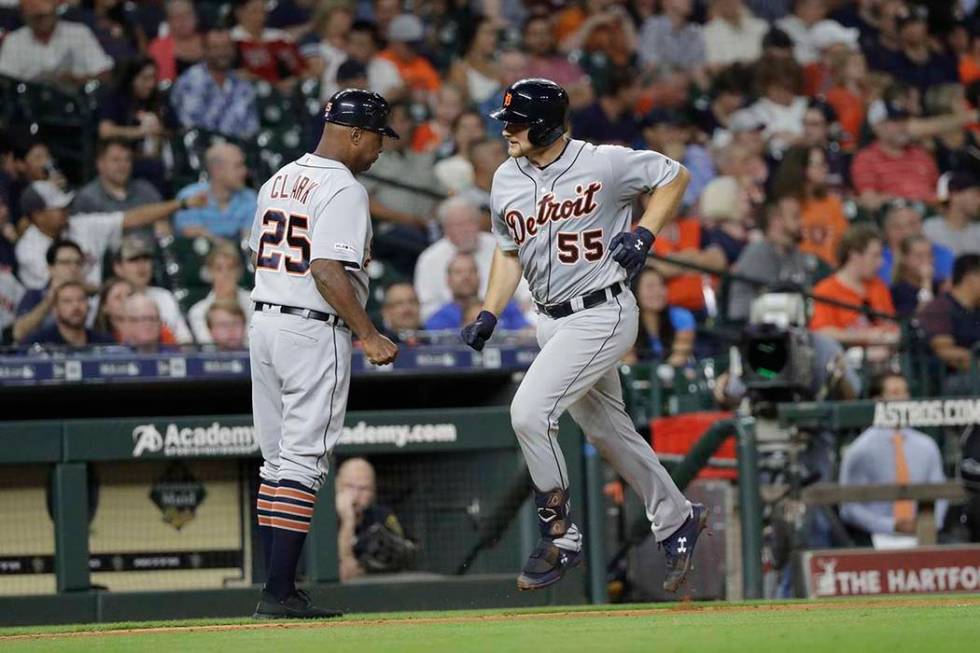 Detroit Tigers' John Hicks (55) celebrates with third base coach Dave Clark (25) after hitting ...