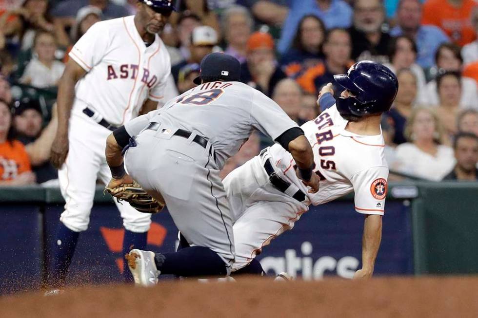 Houston Astros' Jose Altuve, right, is tagged out by Detroit Tigers second baseman Dawel Lugo ( ...