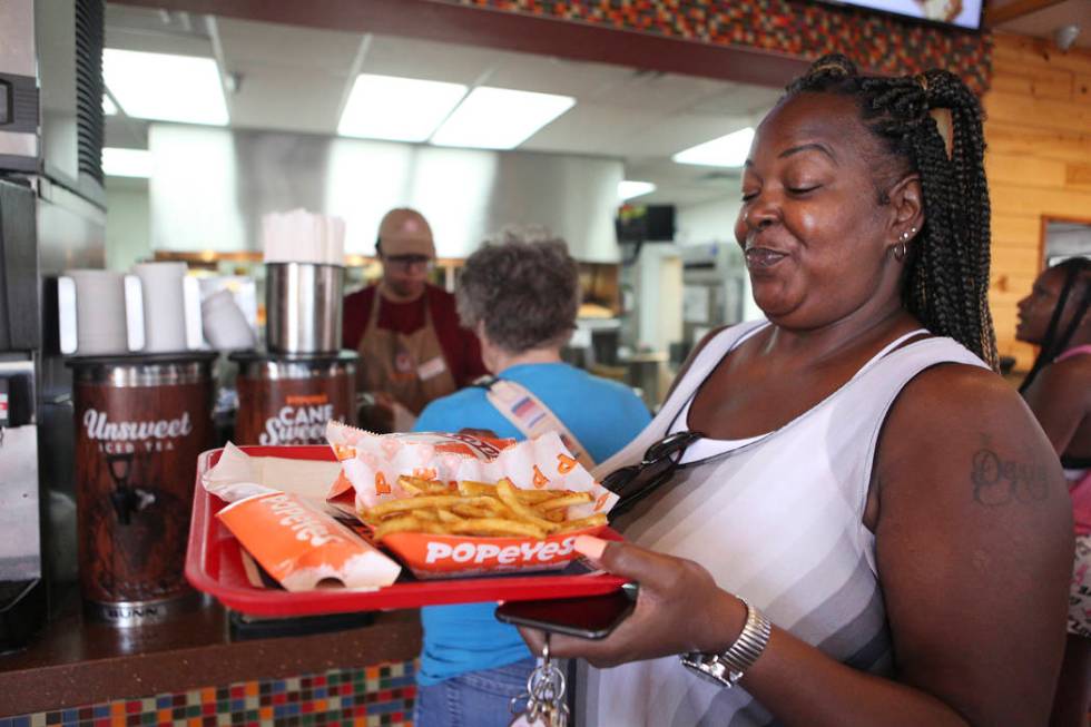 Janine Blake smiles after receiving her spicy chicken sandwich at Popeyes on the corner of Bona ...