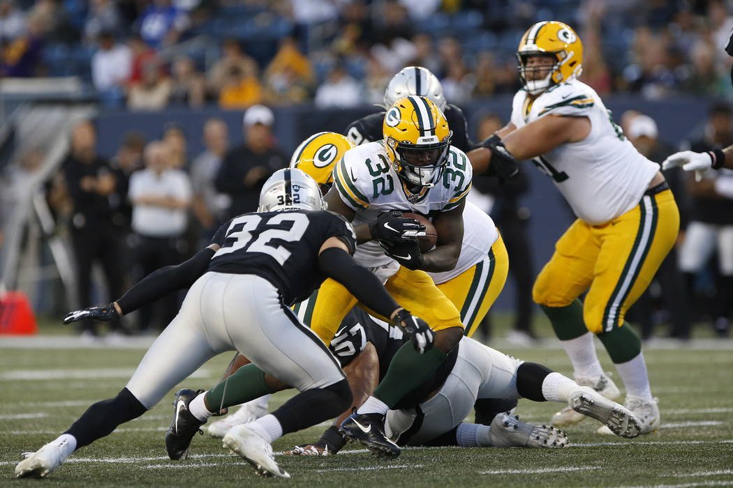 Green Bay Packers' Tra Carson (32) runs against Oakland Raiders' Dallin Leavitt (32) during the ...