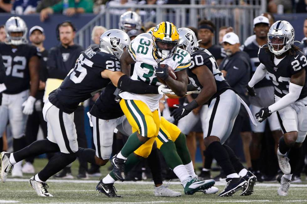 Green Bay Packers' Tra Carson (32) carries as Oakland Raiders' Erik Harris (25) attempts the ta ...