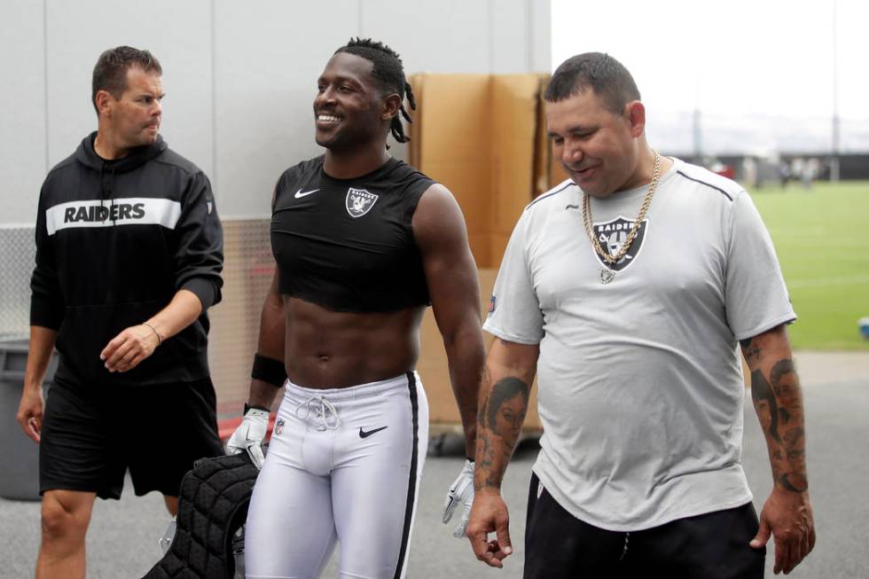 Oakland Raiders' Antonio Brown, center, walks off the field after NFL football practice in Alam ...