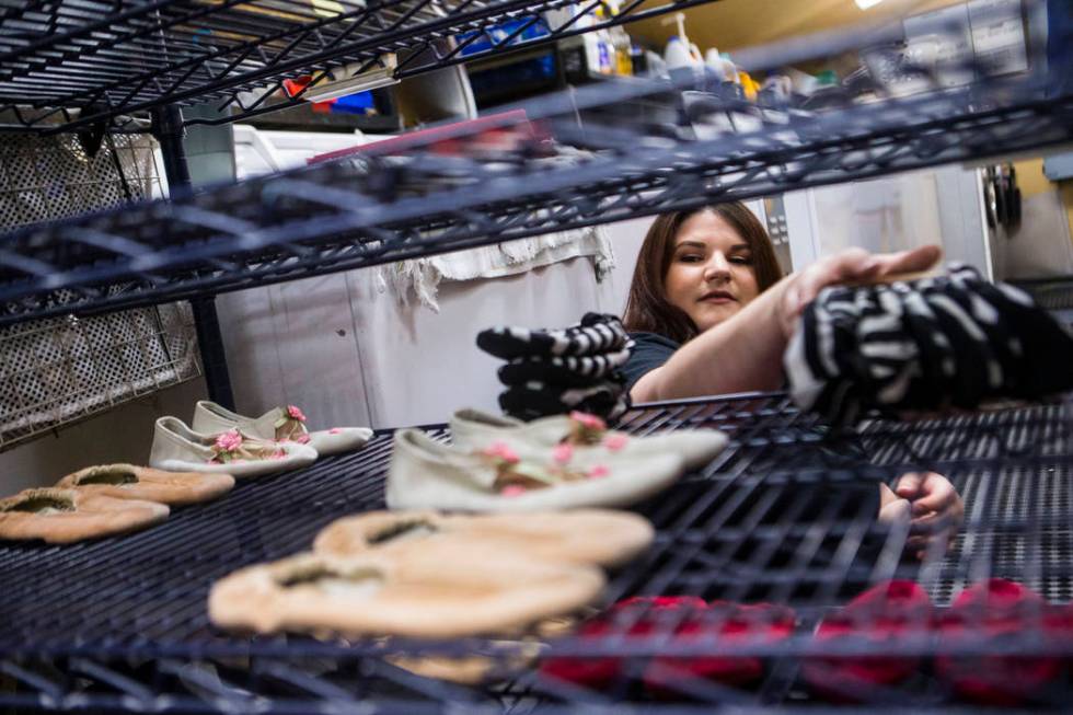 Tyler Cecchini, crafts technician at Cirque du Soleil's "O," organizes shoes in a wardrobe area ...