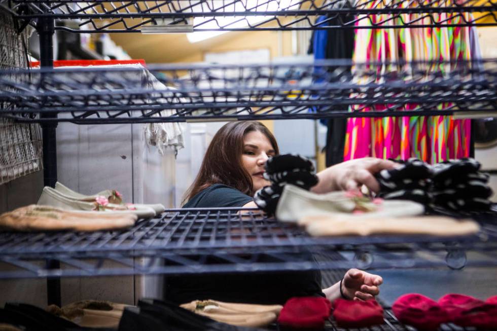 Tyler Cecchini, crafts technician at Cirque du Soleil's "O," organizes shoes in a wardrobe area ...