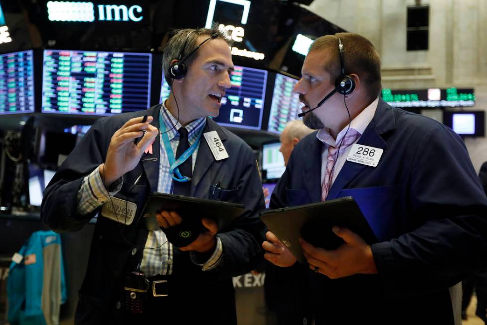 Traders Gregory Rowe, left, and Michael Milano work on the floor of the New York Stock Exchange ...