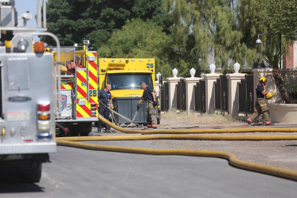 Clark County firefighters pack up equipment after putting out a fire at Mally Mall's home at 43 ...