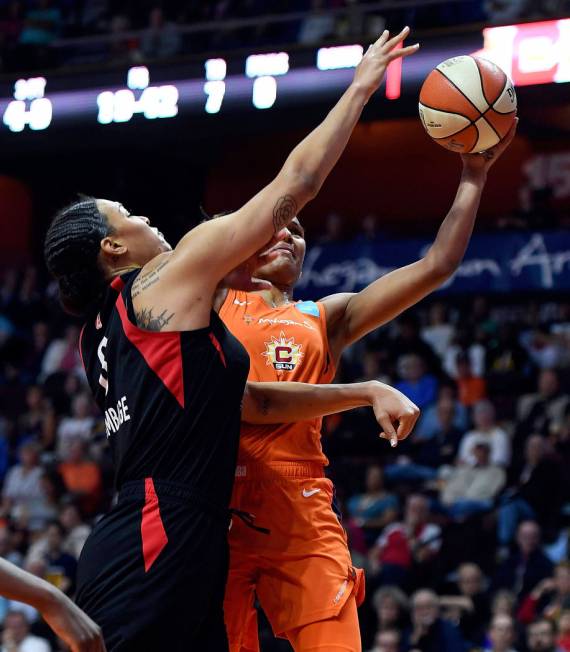 Connecticut Sun forward Alyssa Thomas scores around the defense of Las Vegas Aces center Liz Ca ...