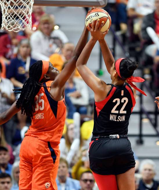 Connecticut Sun center Jonquel Jones, left, blocks a shot attempt by Las Vegas Aces forward A'j ...