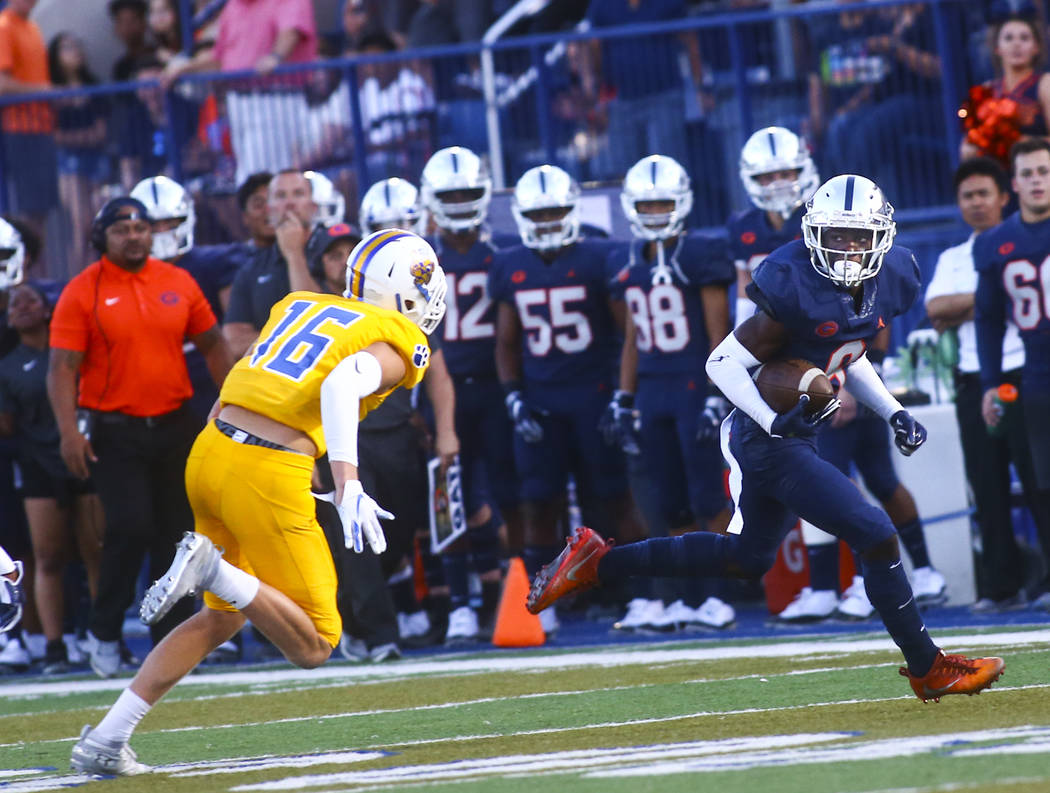 Bishop Gorman's Zachariah Branch (9) runs the ball past Orem's Brody Monson (16) during the fir ...