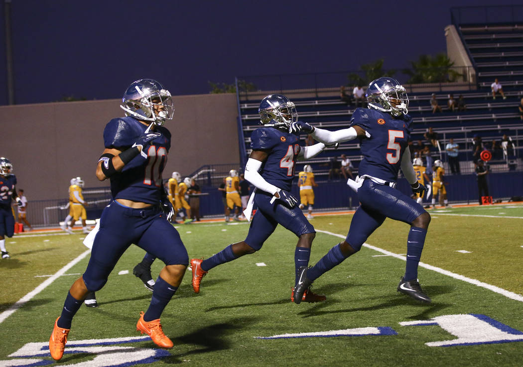 Bishop Gorman players celebrate a touchdown by Fabian Ross, not pictured, during the first half ...