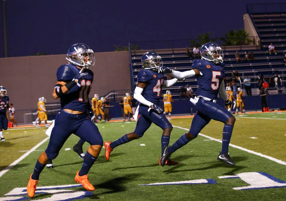 Bishop Gorman players celebrate a touchdown by Fabian Ross, not pictured, during the first half ...