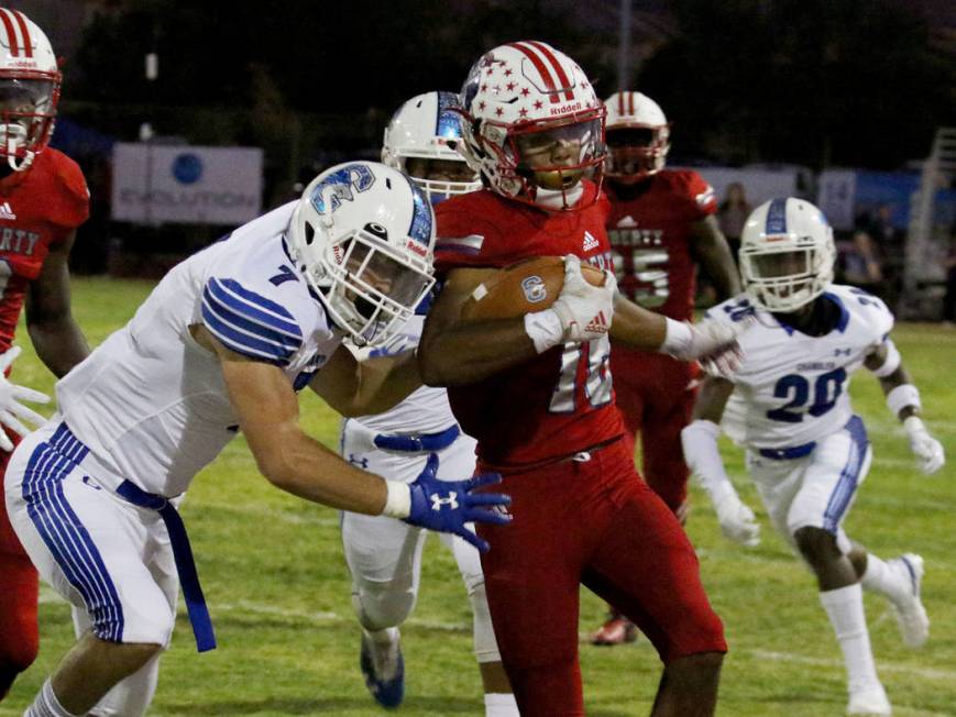 Liberty High's Maurice Hampton (16) tackled by Chandler, Ariz., High's Skyler Price (7) during ...