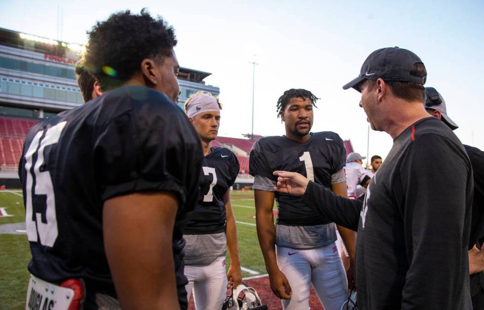 UNLV QB Armani Rogers (1, center) listens with others to quarterback's coach Ron O'Dell, right, ...