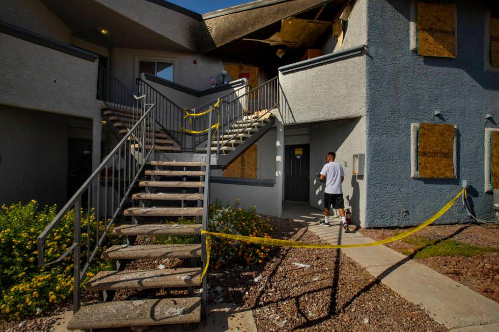 A maintenance worker heads inside a lower apartment where an early morning fire occurred at The ...