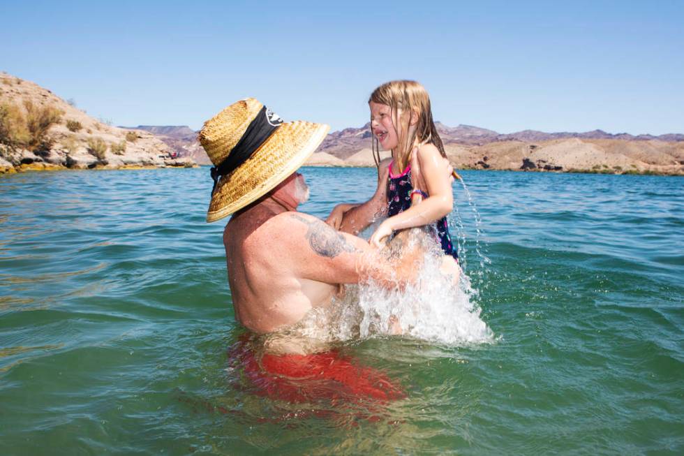 Glenn Cogle picks up his partner's granddaughter Emily Howe, 6, in Lake Mohave at Nelson's Land ...