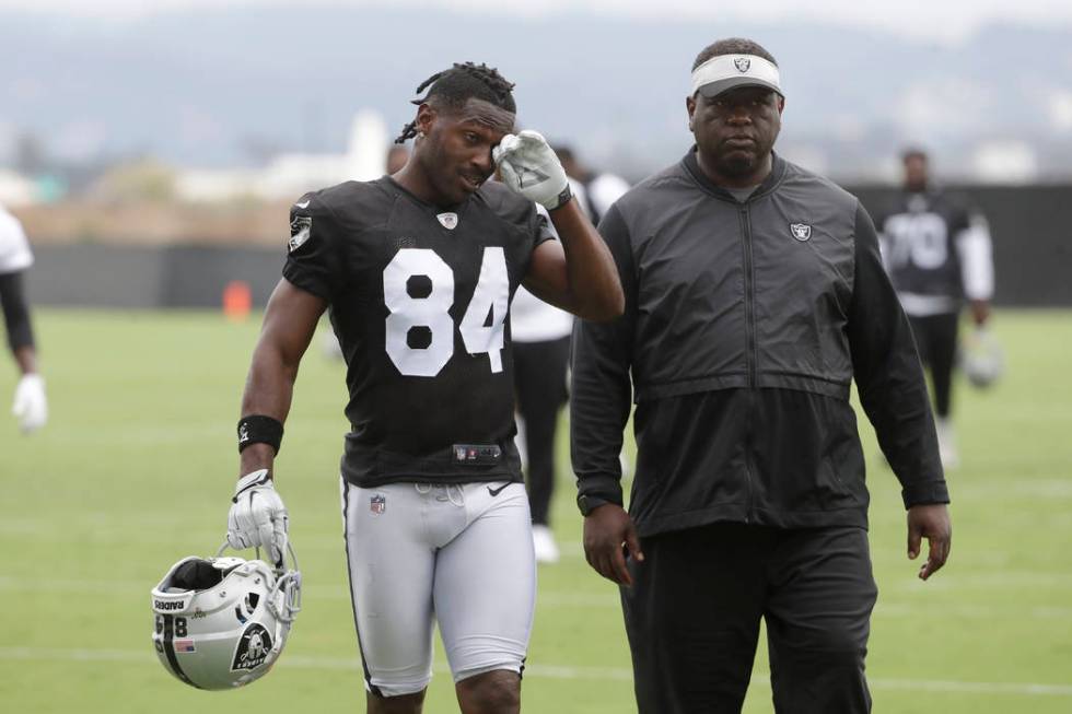 Oakland Raiders' Antonio Brown, left, walks off the field after NFL football practice in Alamed ...