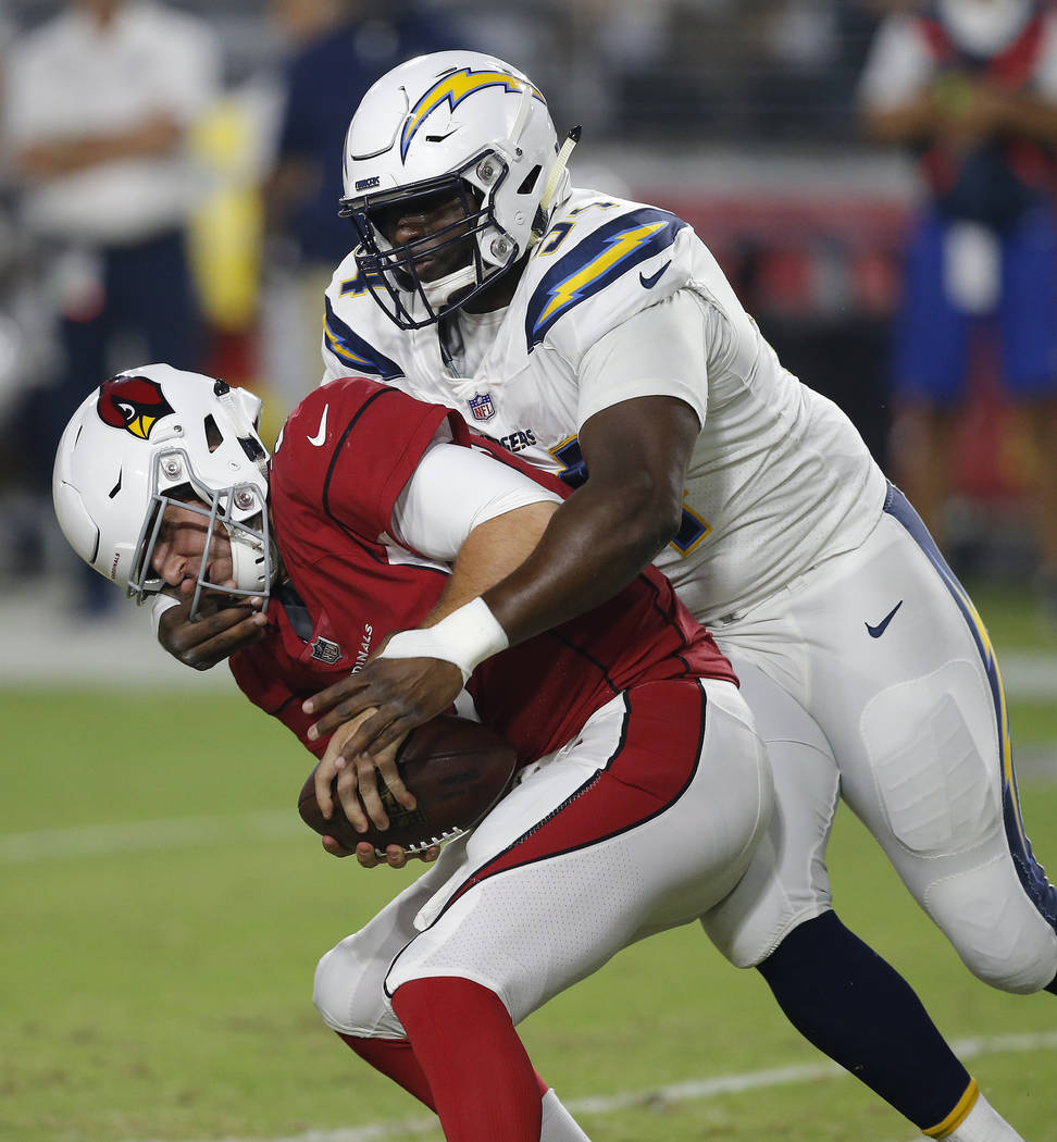 Los Angeles Chargers defensive tackle Corey Liuget (94) grabs the face mask of Arizona Cardinal ...