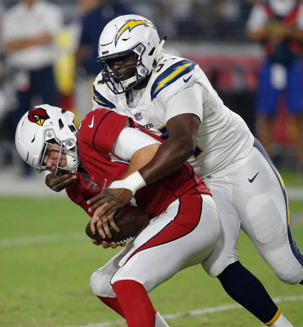 Los Angeles Chargers defensive tackle Corey Liuget (94) grabs the face mask of Arizona Cardinal ...