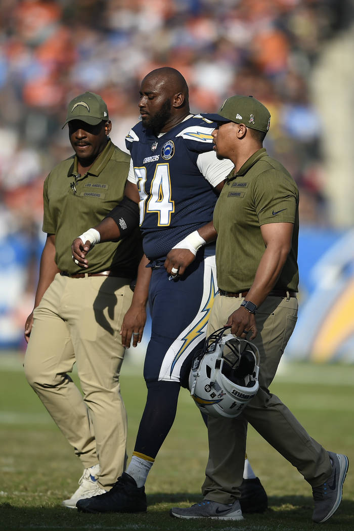 Los Angeles Chargers defensive tackle Corey Liuget is helped off the field after being injured ...