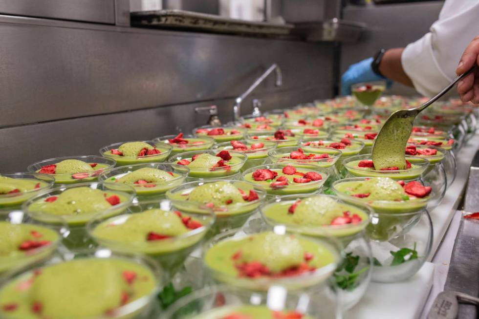 Chilled sweet pea, spinach and mint soup with basil-mint foam and strawberries are prepared for ...