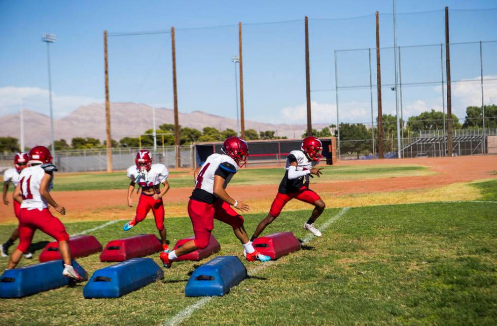 Players run through drills during football practice at the baseball field at Valley High School ...