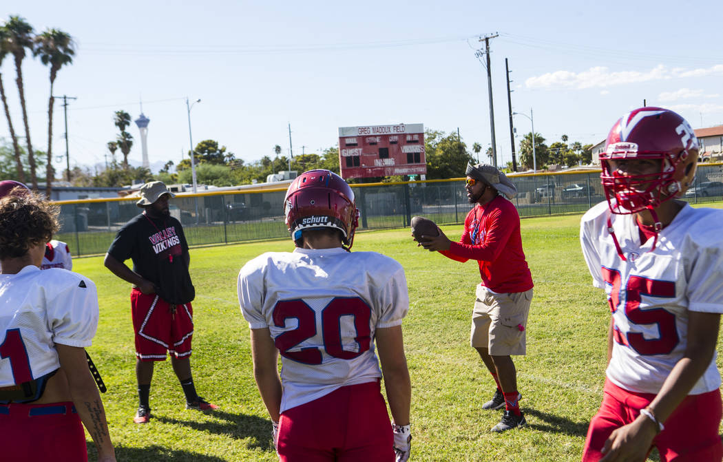Valley coach Quincy Burts, second from right, leads football practice at the baseball field at ...
