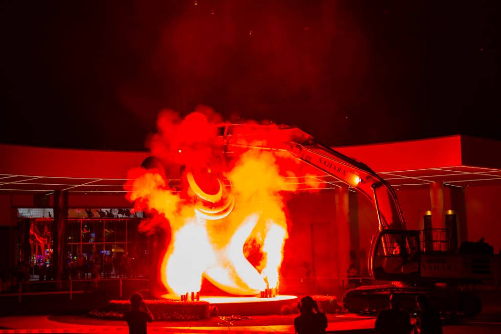 Flames shoot into the air prior to the removal of the "Sam by Starck" statue at the S ...