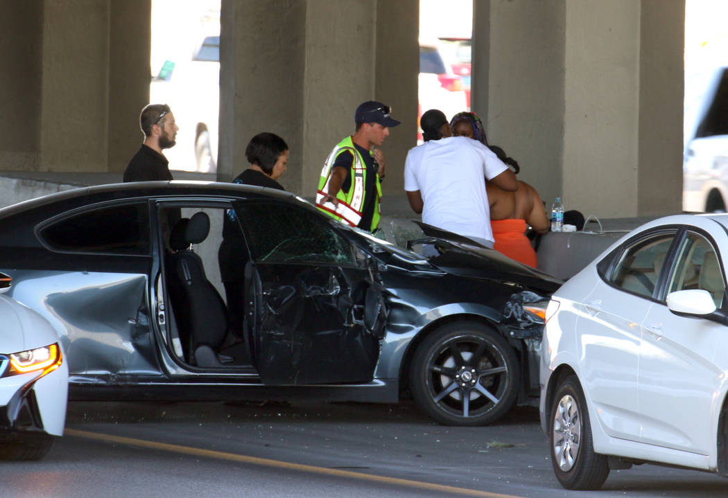 A Las Vegas firefighter assists an injured driver at the scene of multi-vehicle crash at US Hig ...
