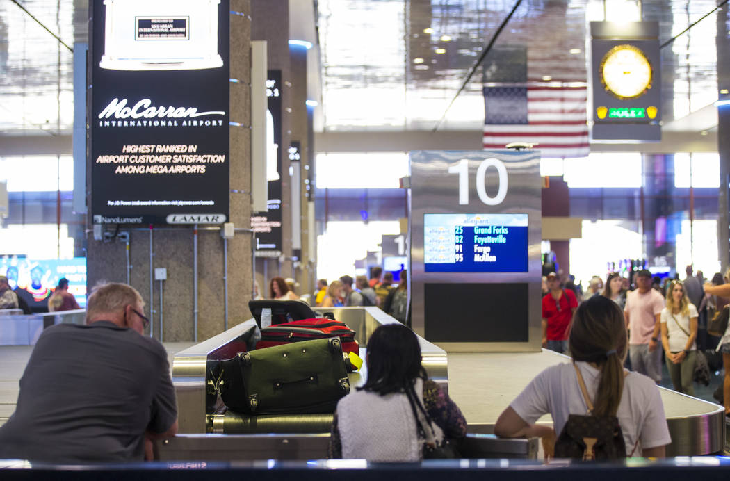 Passengers wait for luggage at the baggage claim area at McCarran International Airport ahead o ...