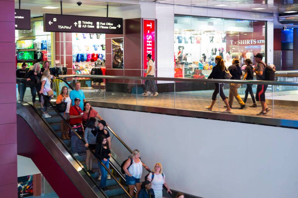 Passengers make their way to baggage claim and transportation at McCarran International Airport ...