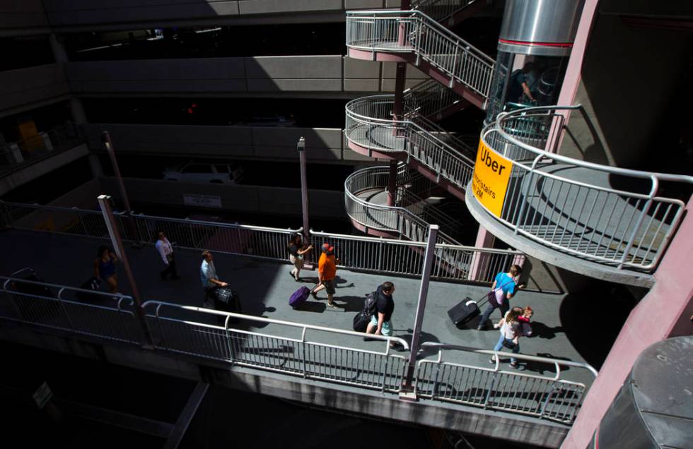 Passengers make their way to rideshare services and parking after arriving at McCarran Internat ...