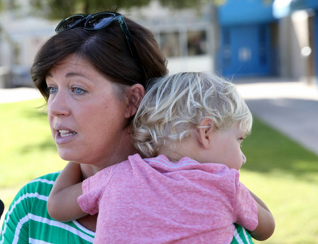 Parent Shellie Tingey talks to a reporter while holding her child Stafford Tingey, 3, at Helen ...
