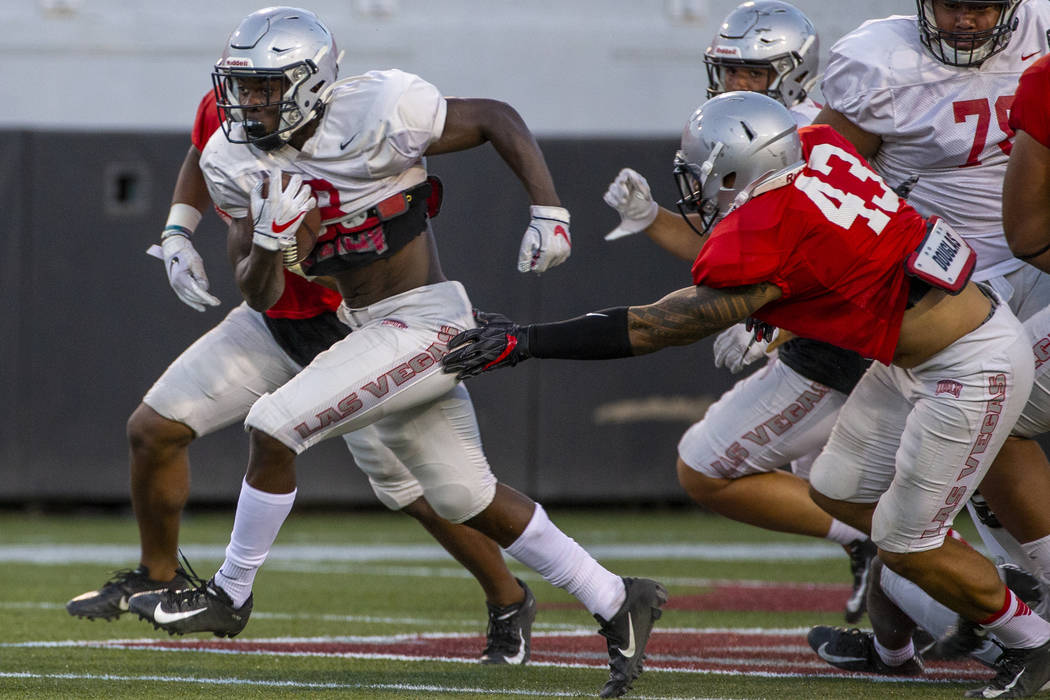 Charles Williams (8) blasts through a hole past defenders including Malakai Salu (43) during th ...