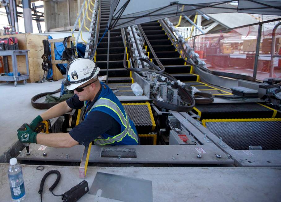 Escalator foreman Cory Johnston works on newly installed escalators at the Raiders Allegiant St ...