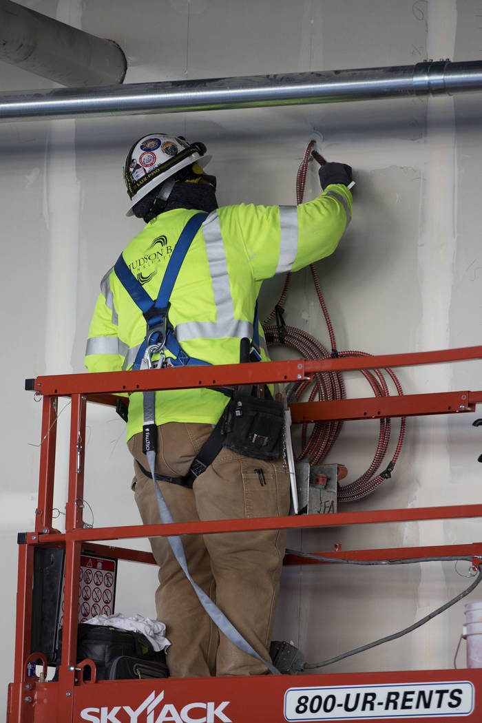 A worker patches a wall at the Raiders Allegiant Stadium construction site in Las Vegas, Wednes ...