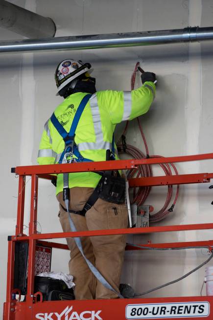 A worker patches a wall at the Raiders Allegiant Stadium construction site in Las Vegas, Wednes ...