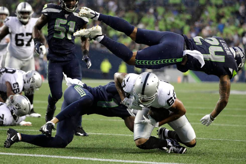 Seattle Seahawks defensive back Shalom Luani (24) flies over Oakland Raiders wide receiver Marc ...